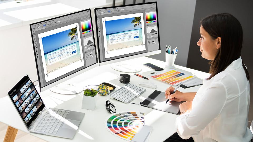 Woman in front of multiple computer monitors