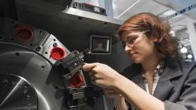 female machining student using machinery