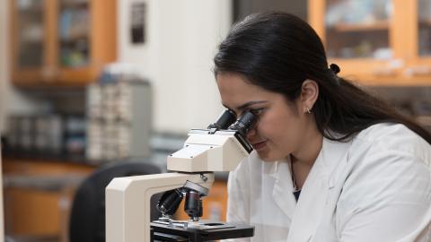 female looking into microscope