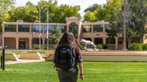 student walking towards building on campus