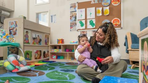 Child being held by an employee in a daycare center