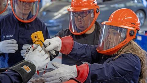 Lucy Amorette, right, tests a battery cell with fellow students, Will Rivas, center, and Christopher Mondragon, far left, at Pueblo Community College Electric Vehicle service class in Pueblo on Thursday, February 19, 2026. (The Gazette, Michael G. Seamans)