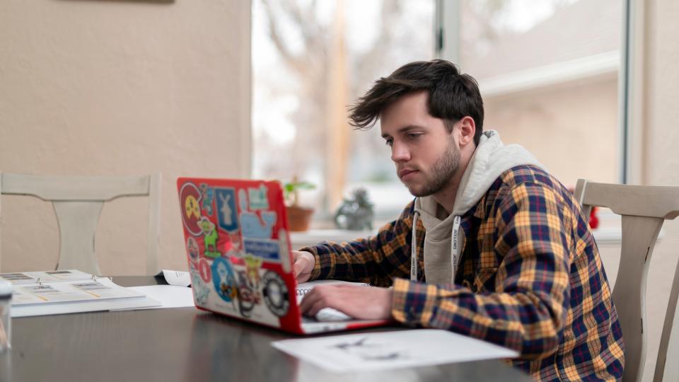 Male student at home with laptop