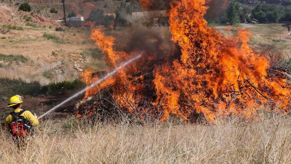 wildland firefighter putting out fire in an open field