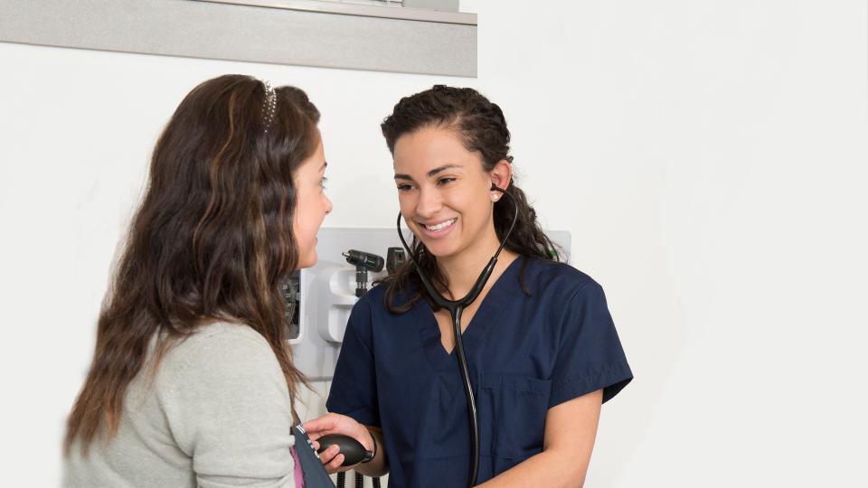 Medical Assistant student checking blood pressure of patient