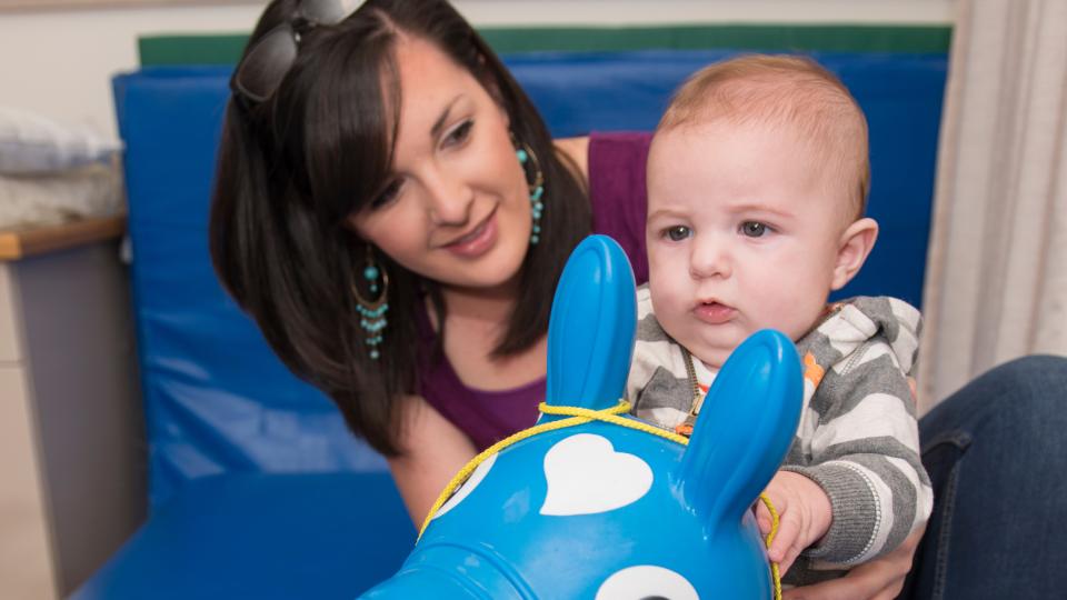 Baby on inflatable horse during therapy session