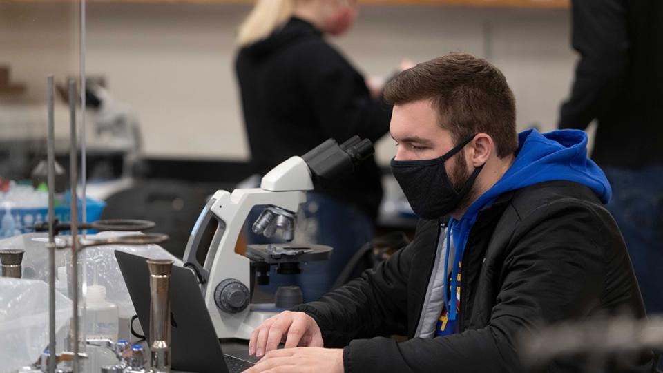 male student at microscope