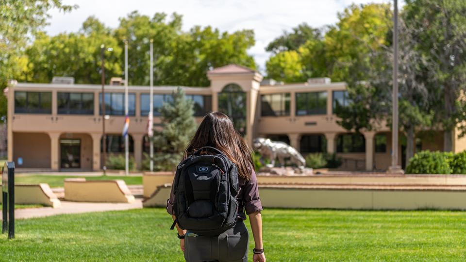 student walking towards building on campus