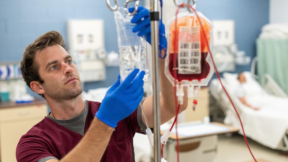 Male nursing student working with IV bags