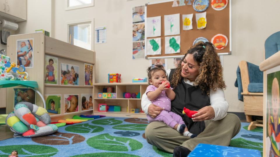 Child being held by an employee in a daycare center