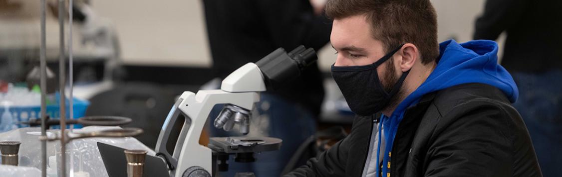 male student at microscope