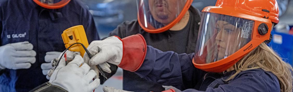 Lucy Amorette, right, tests a battery cell with fellow students, Will Rivas, center, and Christopher Mondragon, far left, at Pueblo Community College Electric Vehicle service class in Pueblo on Thursday, February 19, 2026. (The Gazette, Michael G. Seamans)