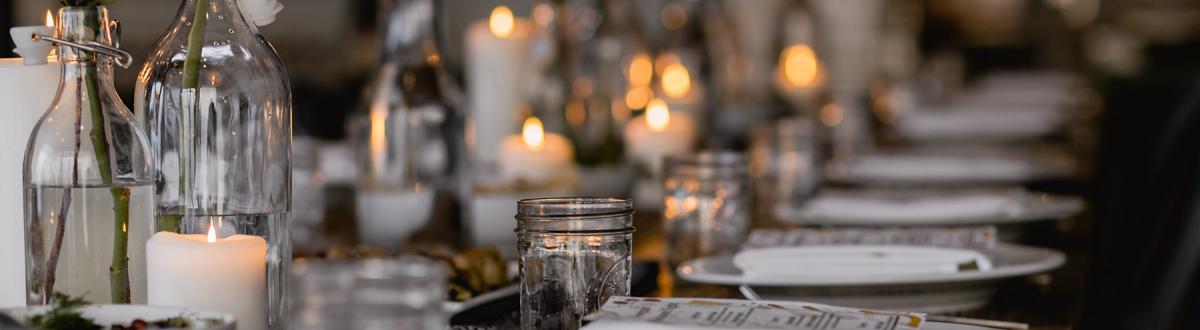 several place settings on dining table with candles