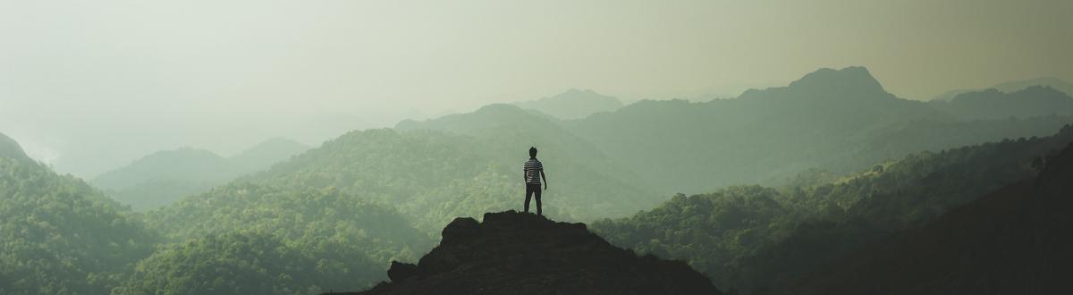 Person standing on top of a mountain