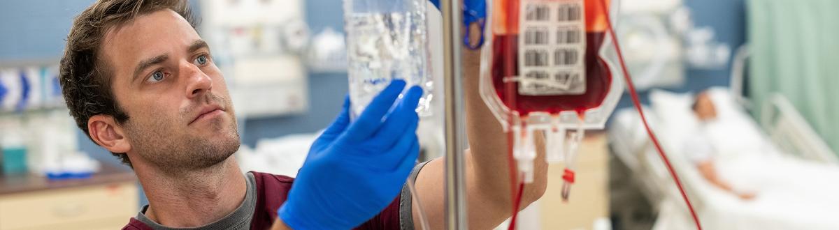 Male nursing student working with IV bags