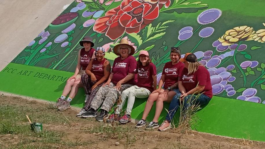 PCC Art students sitting at Levee Mural