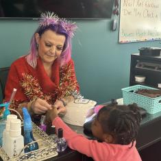 Cosmetology student painting young girl's nails